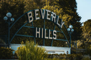 Beverly Hills city sign framed by mature trees and landscaped greenery